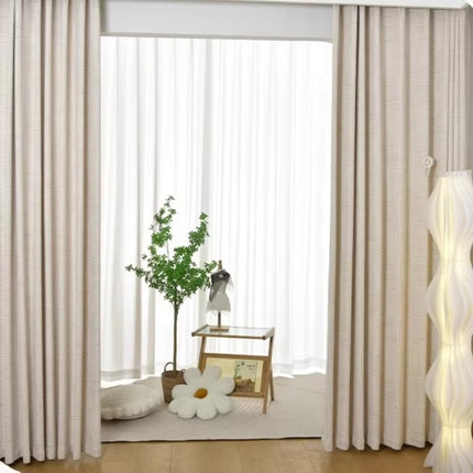 a living room with white curtains and a white chair