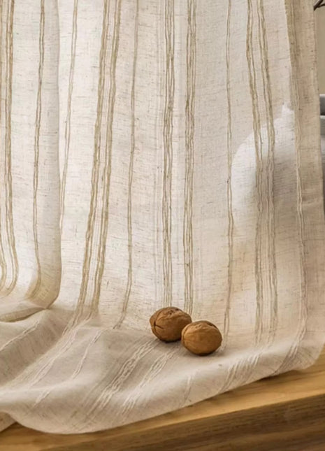 a white curtain with two nuts on a wooden table