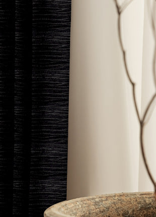 a plant in a vase next to a curtain