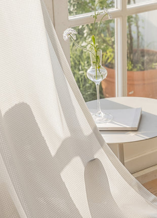 a vase of flowers sitting on a table next to a window