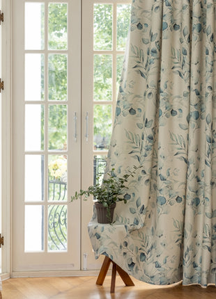 a chair sitting in front of a window covered in curtains