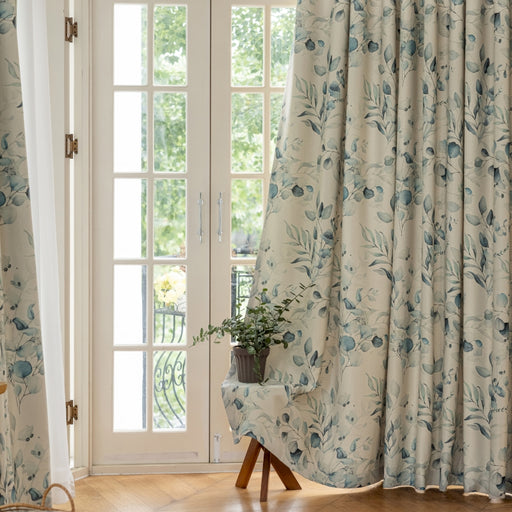 a chair sitting in front of a window covered in curtains