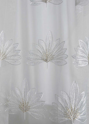 a close up of a shower curtain with leaves on it