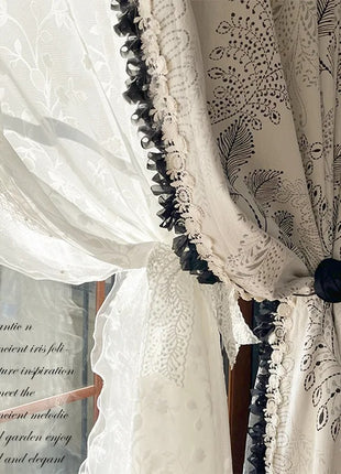 a window with a white curtain and black trim