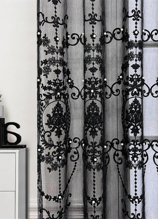 a white dresser sitting next to a window covered in black lace