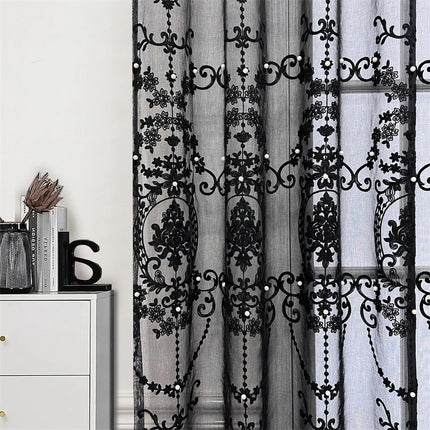 a white dresser sitting next to a window covered in black lace