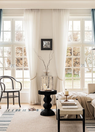 a living room filled with furniture and large windows
