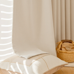 a cozy and inviting living space with a white pillow, a woven basket, and a book on a wooden floor.