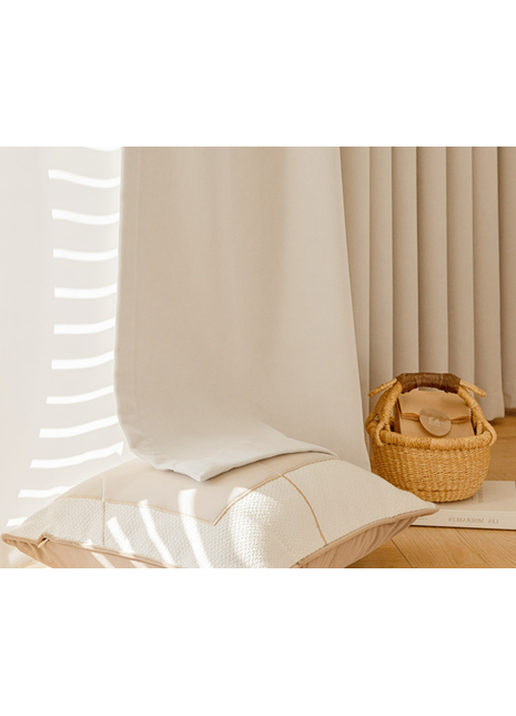 a cozy and inviting living space with a white pillow, a woven basket, and a book on a wooden floor.