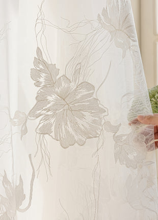 a person holding a flower in front of a curtain