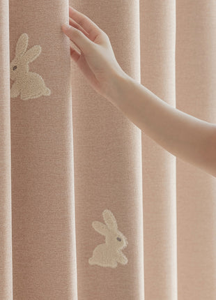a woman is holding a curtain with a rabbit drawn on it