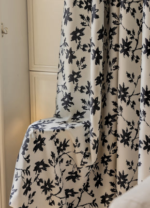 a black and white flowered curtain in a room