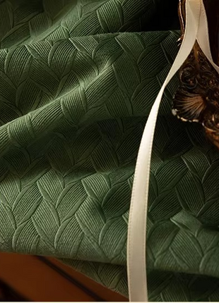 a close up of a green cloth with a white ribbon