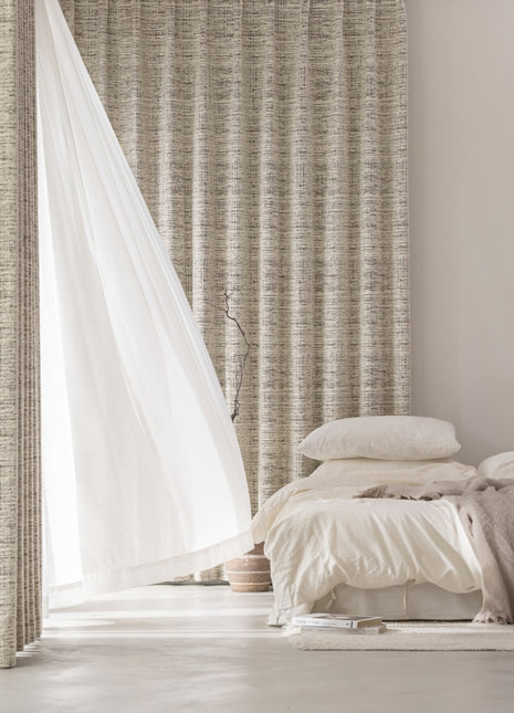 a bed sitting in a bedroom next to a window