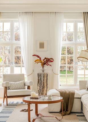 a living room filled with furniture and large windows