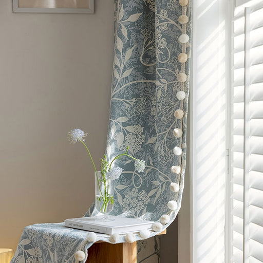 a vase with a flower on a table next to a window