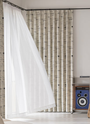 a room with a chair, speakers and a curtain