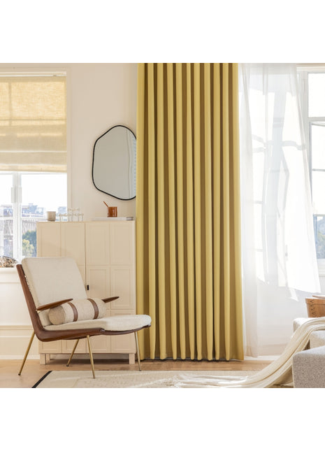 a living room with yellow curtains and a chair