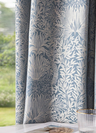 a glass of water sitting on a table next to a window