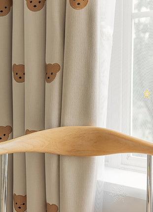 a window with a curtain with a bear pattern on it