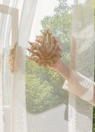 a woman standing in front of a window holding a stuffed animal