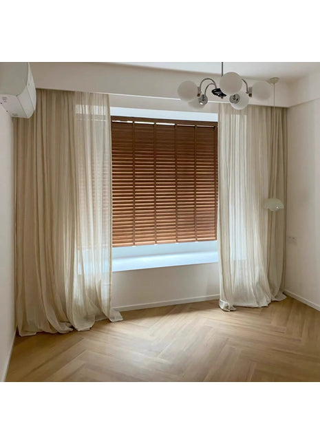 an empty room with a window and a chandelier