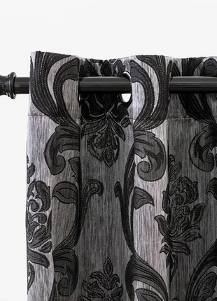 a close up of a curtain with a black and white pattern