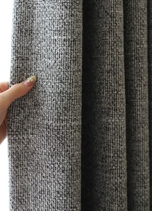 Gros plan sur le tissage chiné gris du rideau, fils clairs et foncés