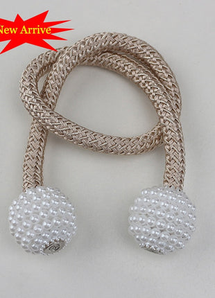 Une paire de perles beige et blanche sur une corde, utilisée comme attache pour rideaux décoratifs.