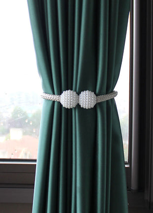 Rideau vert avec deux boules blanches, ajoutant une touche décorative à l'intérieur. Idéal sur Rideaux Déco.