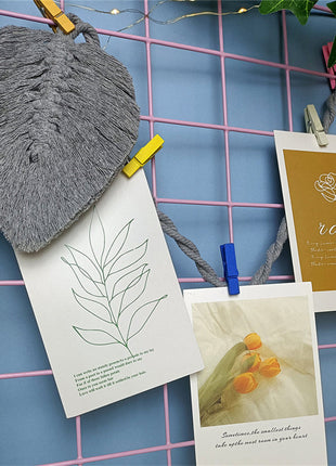 Attache Rideau Corde. Un groupe de cartes suspendues à une corde à linge, ajoutant une touche décorative à l'espace.