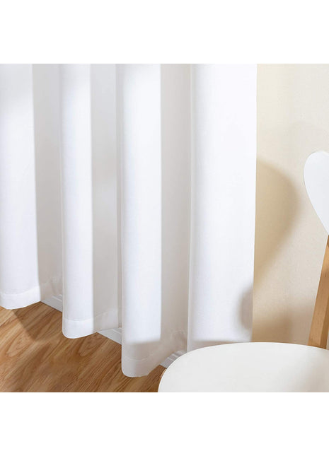 Rideau opaque blanc uni et mat, drapé en plis dans un intérieur clair au parquet bois
